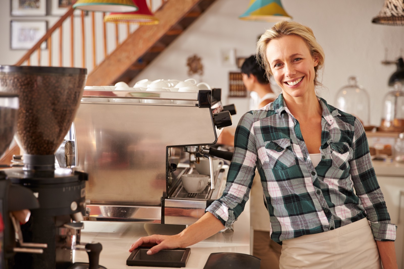 Smiling cafe owner at her espresso machine