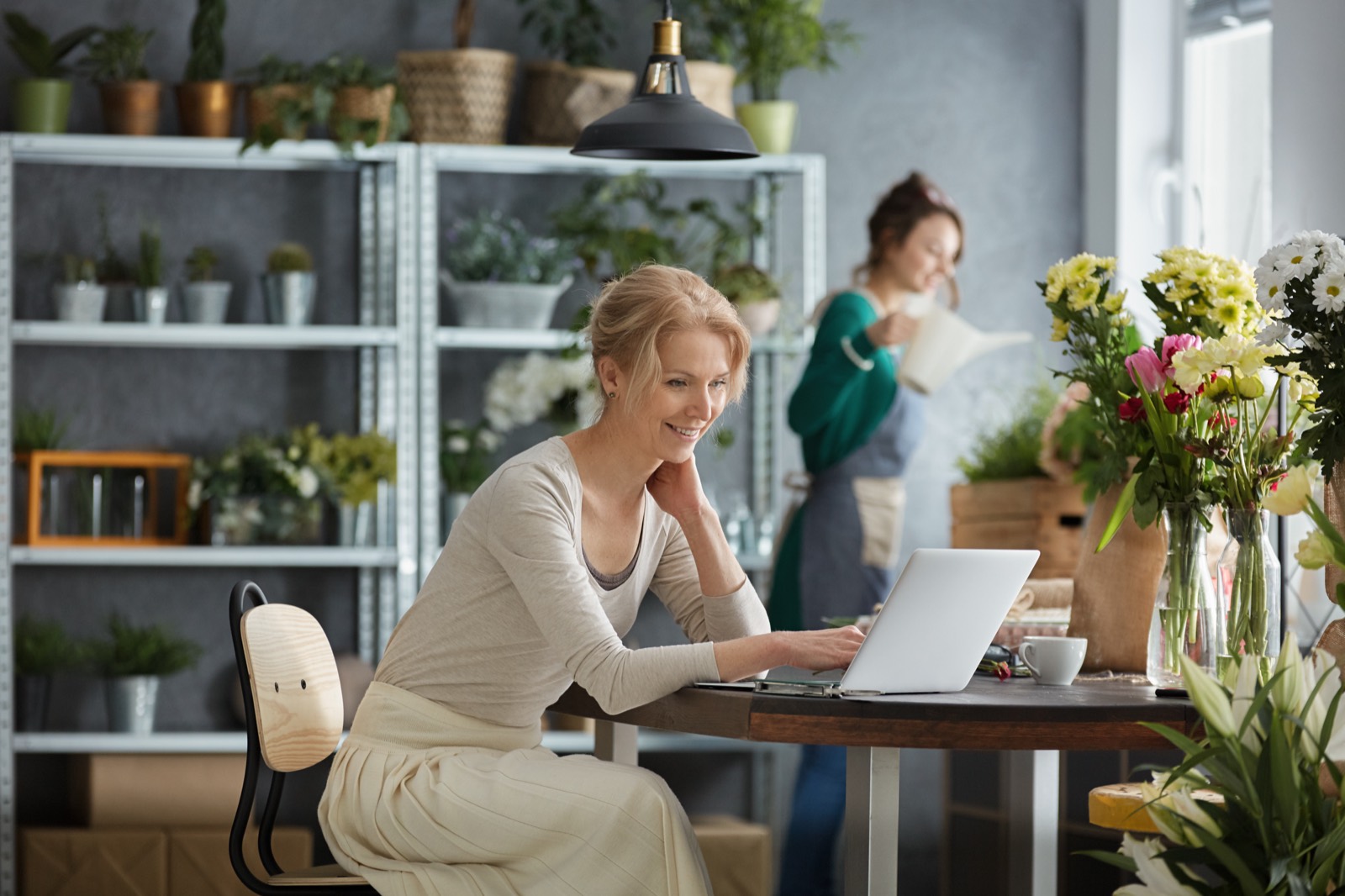 Florist smiling while working on her laptop